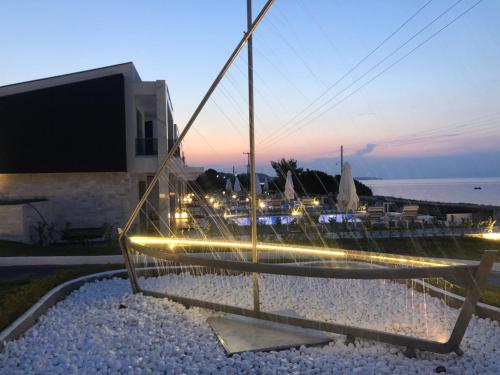 a pole with lights on a beach at night at Crystal villas & suites in Polykhrono