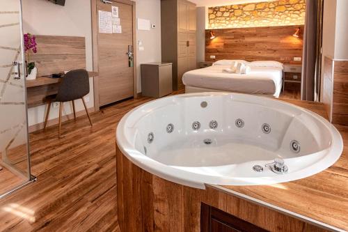 a large bath tub in a room with a bed at Hotel Gastronómico Torre de Galizano in Galizano