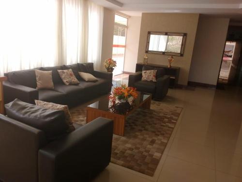 a living room with a couch and chairs and a table at Di Roma Rio Quente in Rio Quente