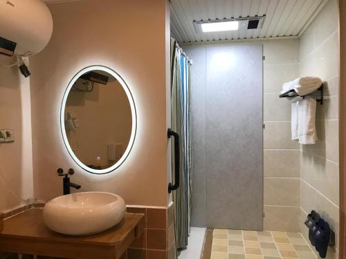 a bathroom with a sink and a shower at Enshi Grand Canyon Chunlun Farmstay in Enshi