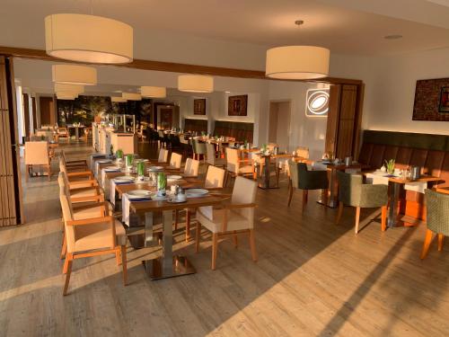 un restaurante con mesas de madera y sillas en una habitación en Hotel-Restaurant Goldenstedt, en Delmenhorst