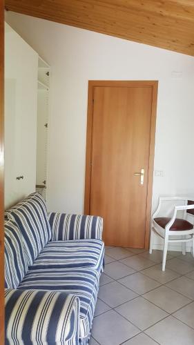 a living room with a couch and a wooden door at CROTTO CARACO APPARTAMENTI BUNGALOW CHALET in Porlezza