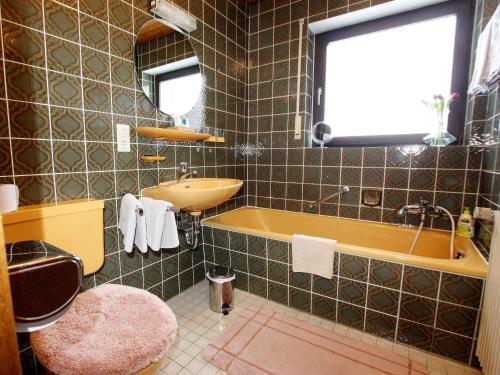 uma casa de banho com um lavatório, uma banheira e um WC. em Gästehaus Absbachtal em Bad Rippoldsau-Schapbach