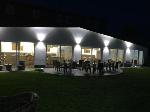 a patio with a table and chairs at night at Hotel-Restaurant Goldenstedt in Delmenhorst