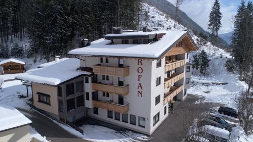 a hotel building with snow on the roof at Appartements Rofan in Maurach