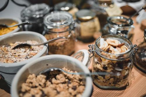 a table with jars of granola and a bowl of nuts at Guesthouse St Nikolaus in Ultimo