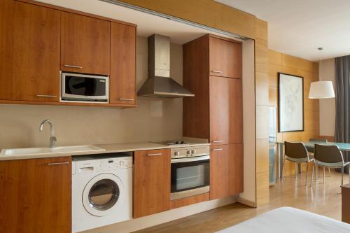 cocina con lavadora y microondas en Wello Apartments, en Barcelona