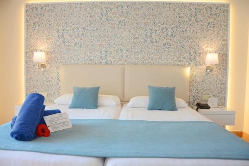 a hotel room with two beds with a stuffed animal on the bed at Aldiana Club Andalusien in Chiclana de la Frontera
