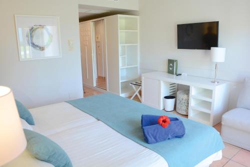 a bedroom with a bed with a red flower on it at Aldiana Club Andalusien in Chiclana de la Frontera