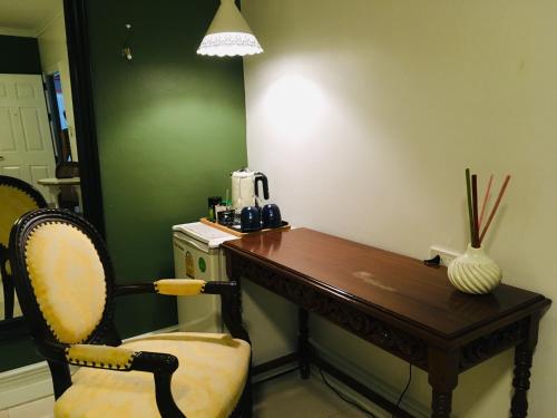 a wooden desk with a chair and a vase at Bed in Town in Chiang Mai