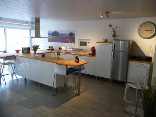 una cucina con bancone, frigorifero e tavolo di Éco Gîtes Aubelrando & villa-bocage ad Aubel