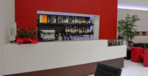 a bar in a room with a red wall at Ibis Styles Milano Centro in Milan
