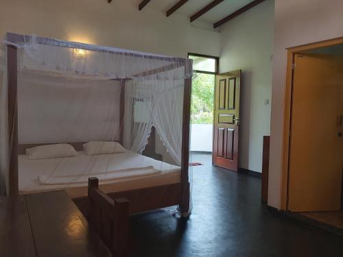 1 dormitorio con cama con dosel en una habitación en Sunstyle Mirissa Guest House, en Mirissa