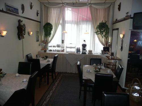 una sala da pranzo con tavoli, sedie e una finestra di Staten Hotel a L'Aia