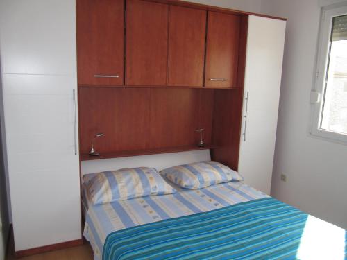 a bedroom with a bed and wooden cabinets at Apartmani Marino in Vinišće