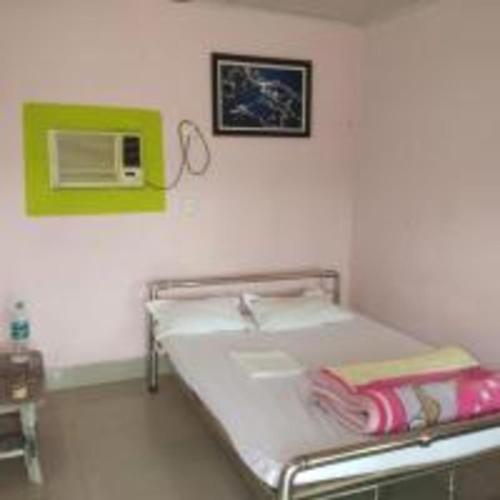 a hospital room with a bed and a microwave at Gorumara Nature's Cottage (A Unit Of M/S Ecological & Tours) in Jalpāiguri