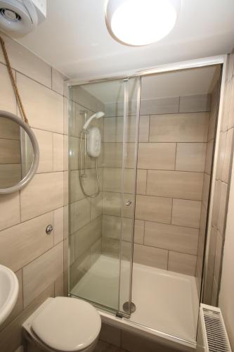a bathroom with a shower with a toilet and a sink at Serviced Accommodation Moray in Elgin