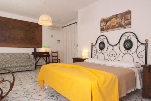 伊斯基亞的住宿－Hotel Belsole，一间卧室配有一张大床,床上有黄色的毯子