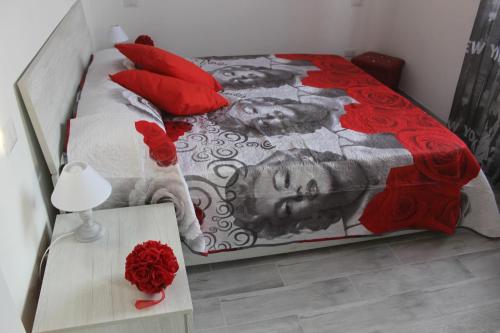 Schlafzimmer mit einem Bett mit roten Kissen und einem Tisch in der Unterkunft Pisa Apartment Tower in Pisa