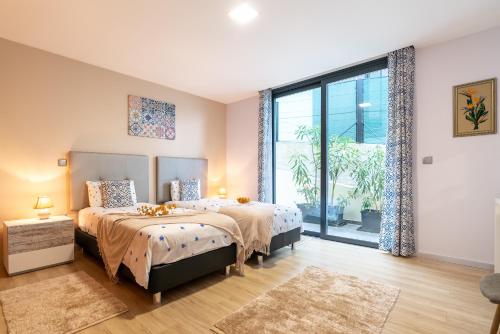 ein Schlafzimmer mit zwei Betten und einem großen Fenster in der Unterkunft Apartamento Goncalves in Arco da Calheta