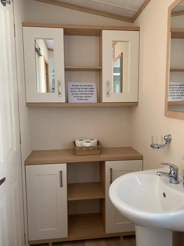 łazienka z umywalką i 2 lustrami w obiekcie Invernevis w mieście Boat of Garten