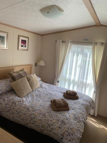 a bedroom with a bed with two towels on it at Invernevis in Boat of Garten