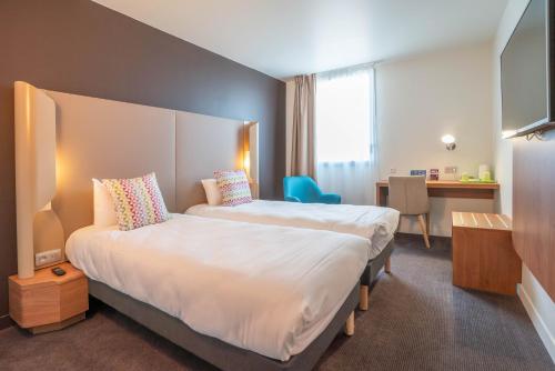 une chambre d'hôtel avec un grand lit et un bureau dans l'établissement Campanile Tours Nord, à Tours