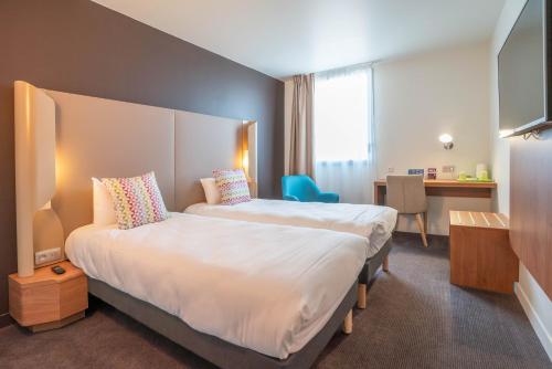 een hotelkamer met een groot bed en een bureau bij Campanile Tours Nord in Tours