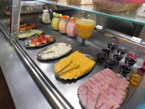 a buffet line with different types of meats and cheese at Hotel Real São Lourenço in São Lourenço