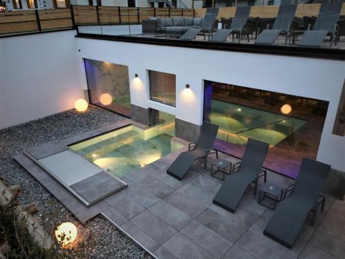 an overhead view of a pool with chairs and a fireplace at Hotel Concordia in Livigno