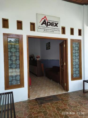 una habitación con dos puertas y un cartel que diga "apex" en Penginapan APEX en Dobo