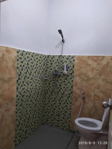 a bathroom with a shower with a toilet at Penginapan APEX in Dobo