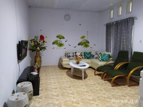 Penginapan APEX في Dobo: غرفة معيشة مع أريكة وكراسي وطاولة
