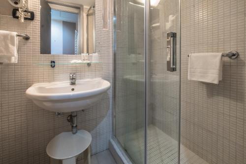 a bathroom with a shower, sink, and toilet at Canova Hotel in Milan