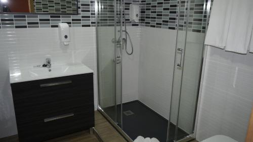 uma casa de banho com um chuveiro e um lavatório. em Hostal La Pared em Torres de la Alameda