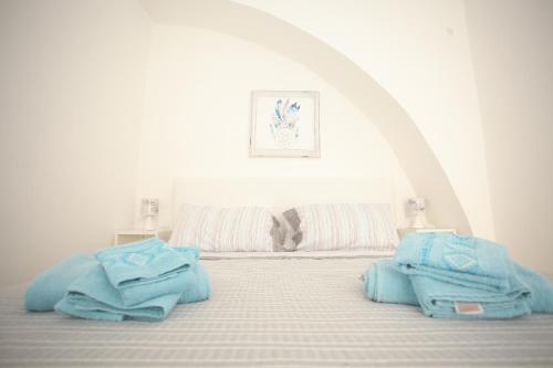 Un dormitorio con una cama con toallas azules. en Corso Garibaldi 22 apartment, en Paola