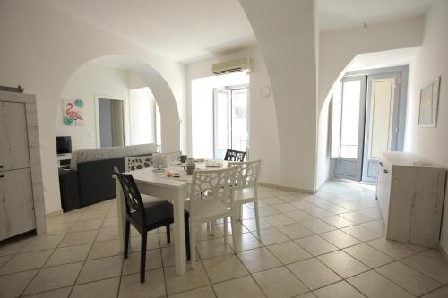 - une salle à manger blanche avec une table et des chaises blanches dans l'établissement Corso Garibaldi 22 apartment, à Paola