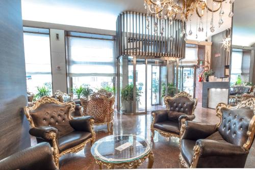 un vestíbulo con sillas de cuero y una lámpara de araña en Canova Hotel en Milán