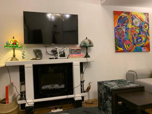 uma sala de estar com lareira e televisão de ecrã plano em Charming studio apartment in the heart of the Jewish District! em Cracóvia