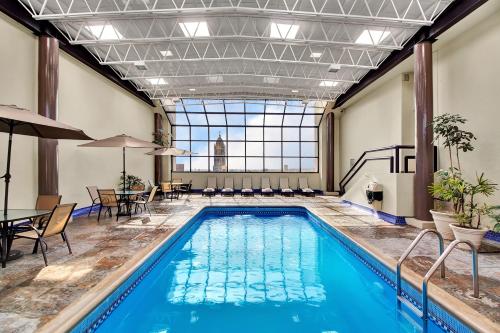 a pool with chairs and a table in a room at Everest Ciudad Victoria in Ciudad Victoria