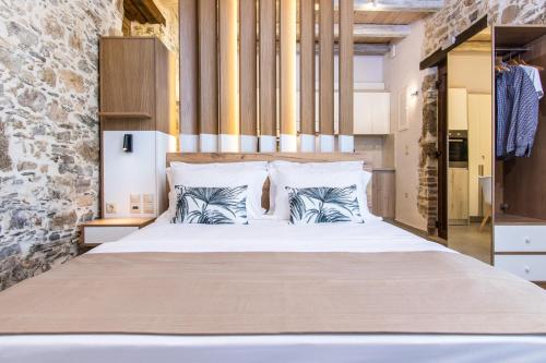 a bedroom with a large bed with two pillows at Stairs Homes & Suites in Kamária