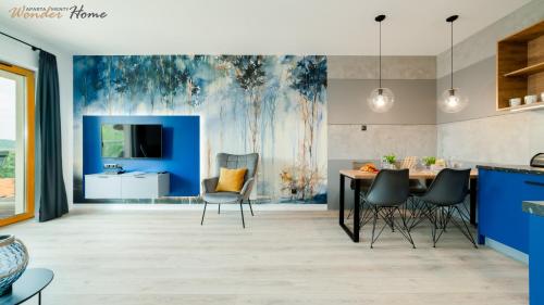 cocina con paredes azules, mesa y sillas en Wonder Home - Apartamenty z widokami i blisko szlaków - w spokojnej części Karpacza, en Karpacz