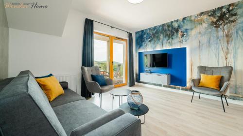 a living room with a couch and chairs and a tv at Wonder Home - Apartamenty z widokami i blisko szlaków - w spokojnej części Karpacza in Karpacz