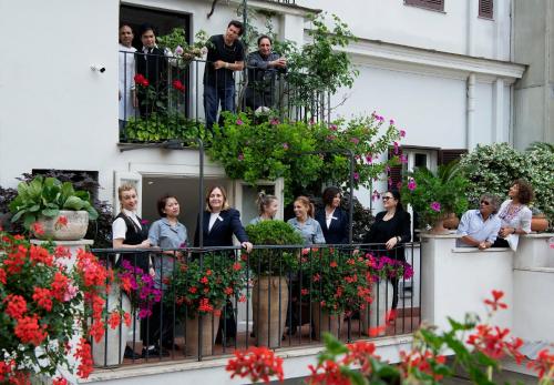 a group of people standing on a balcony with flowers at Alpi Hotel in Rome