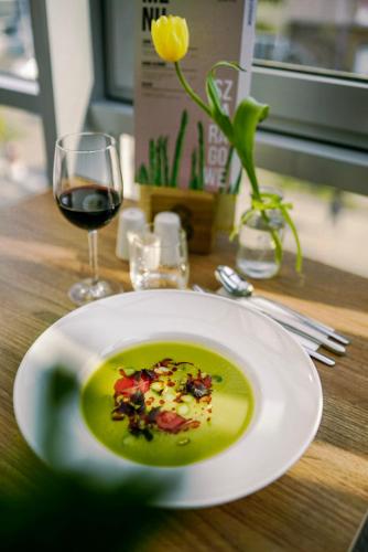 a plate of soup and a glass of wine on a table at poznańska19 in Nowy Tomyśl