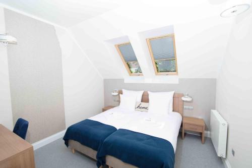 a bedroom with a bed and two windows at Hudson in Koszalin