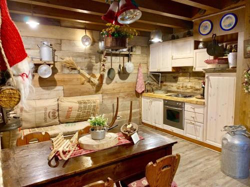 a kitchen with a table and a couch in it at ALLA STALLA Suite & Chalet in Piazzatorre