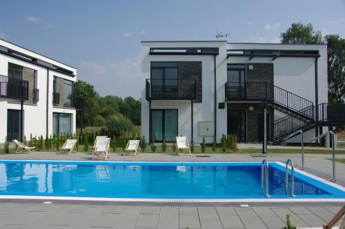a swimming pool in front of a house at Rayo del Sol Łukęcin in Łukęcin
