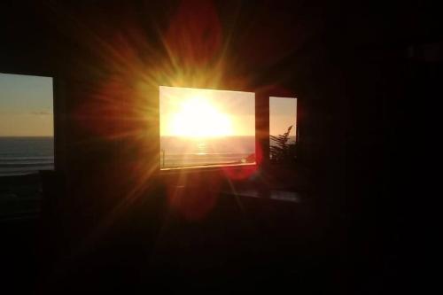 a sunset seen through the window of a building at Loft Playa Puertecillo, mar y sunset increíble in Puertecillo