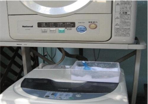 una lavatrice con un contenitore sopra di Narita U-City Hotel / Vacation STAY 42505 a Narita
